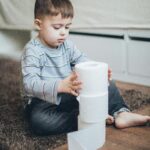 boy stacking toilet rolls, credit- pexels-elly-fairytale-4008829